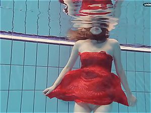 red clothed teenager swimming with her eyes opened